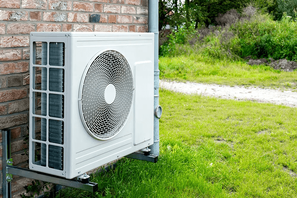 A heat pump mounted on the brick exterior of a Houston home